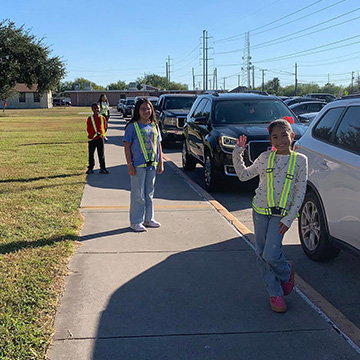 Students standing next to the street with their safety gear