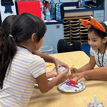 three students working together on a craft project