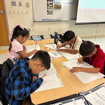 four students working on their schoolwork