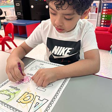 Student coloring a page for the letter A