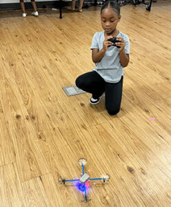 female student working remote control for drone