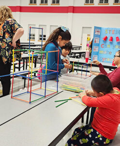family of four working together to complete a STEM building activity