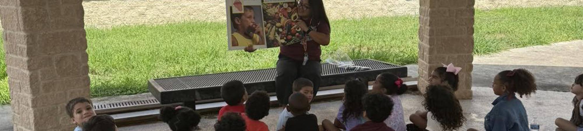 Teacher reading to students outside