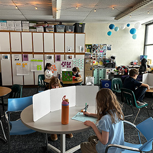 Student writing in a classroom