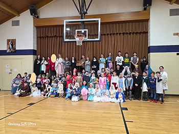 Group photo of students wearing costumes in a gym