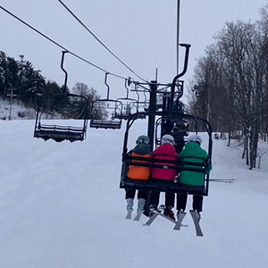 Three students sitting on the ski lift