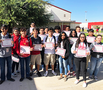 Proud students outside holding up award certificates