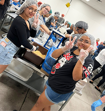Students helping to make meals in a kitchen