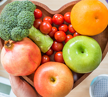 Fresh fruits and vegetables in a heart-shaped bowl
