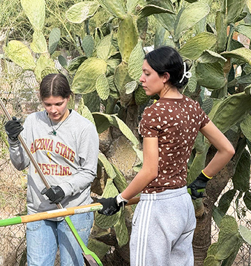 Two NHS members helping with a community clean up project