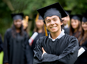 Proud male student in graduation cap and gown