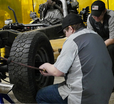 Students working on tires in a garage