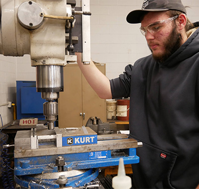 Student working on a vertical drill press