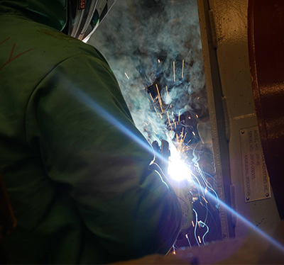 Student welding in their protection gear