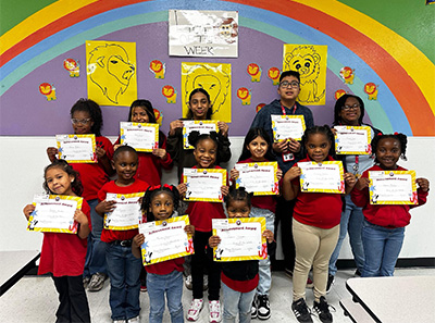 Group of happy students holding up certificates