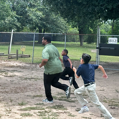 Teacher running outside with students