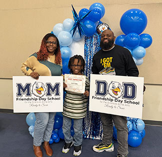 Proud student with parents under celebration balloons