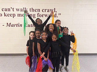 Group of happy students in front of a mural