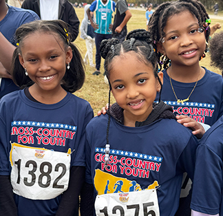 Three happy girls wearing running bibs