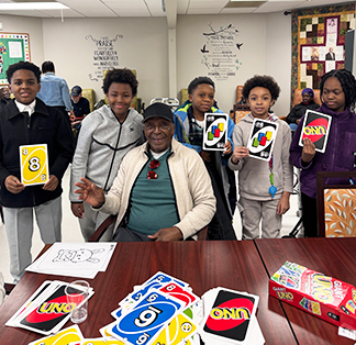 Group of students playing the game of Uno with seniors