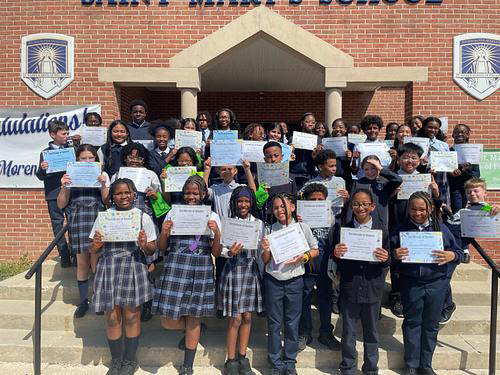 Group of happy student proudly holding up honor roll certificates