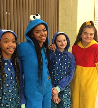 Four happy middle school girls in costumes