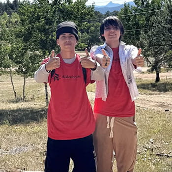 two students giving a double thumbs up