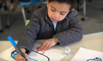 Little boy coloring at his desk