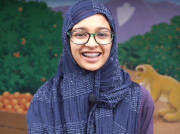 female student in front of a mural