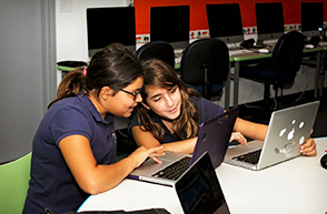 Female students use laptops in class