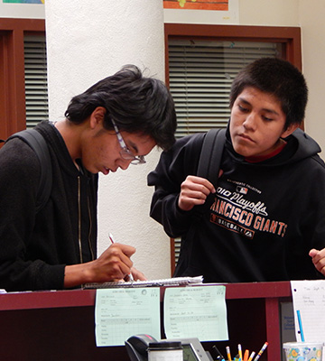 Two students reading information in a notebook
