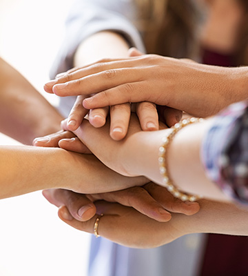 People stacking their hands on top of each others