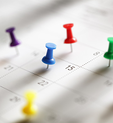 A calendar with colorful stickpins