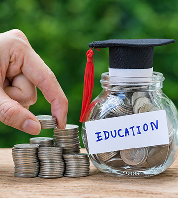 A coin bank with the word Education on it next to stack of coins