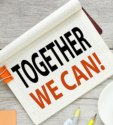A parent holding their child's hand as they walk to school together