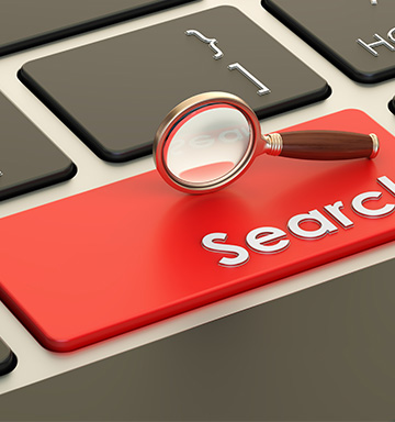 A magnifying glass on the search button of a keyboard