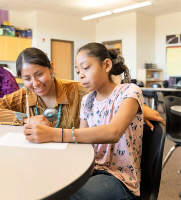 Teacher helping a student at her desk
