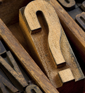 Question marks carved in wood pieces