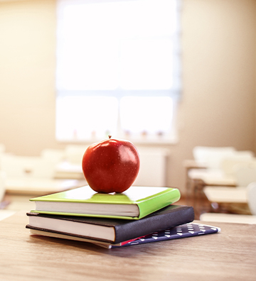 Red apple on top of notebooks