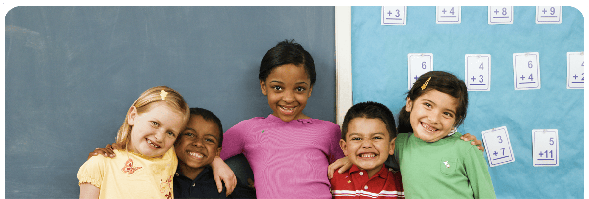 Five students pose in front of a blackboard
