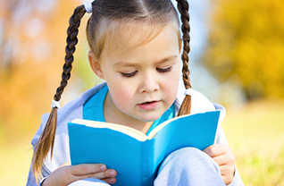 Female student reads a book outside