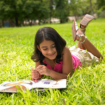 Girl reading a book on the grass