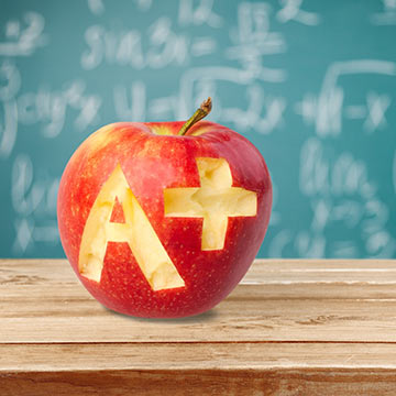 An apple with A plus carved into it