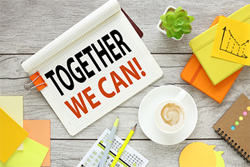 Together We Can! sign on a desk with other office supplies