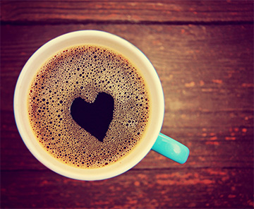 Big cup of coffee with a heart-shaped foam on the top
