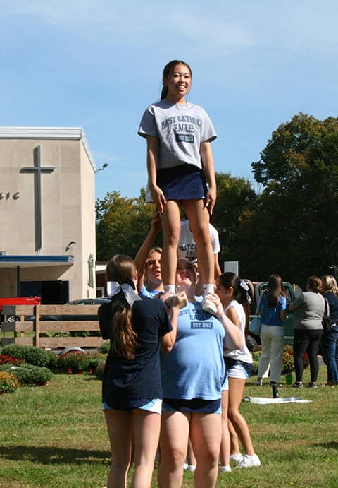 Cheerleaders working on stunts