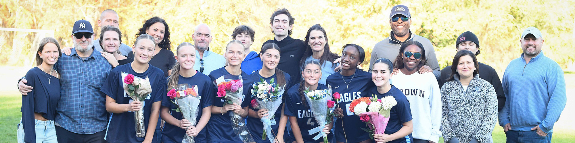 Adults with students holding flowers