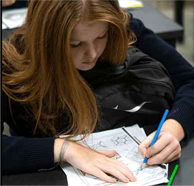 Student writing answers to homework