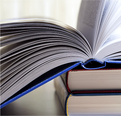 Blue book open on top of two other books