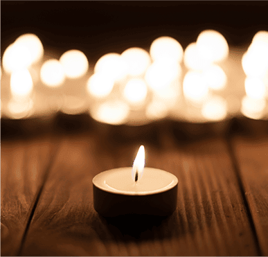 A lit candle on a wooden table